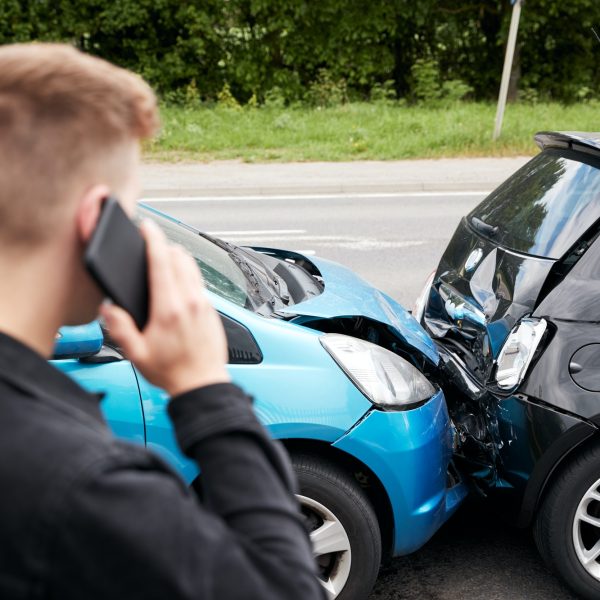 young-male-motorist-involved-in-car-accident-calling-insurance-company-or-recovery-service.jpg